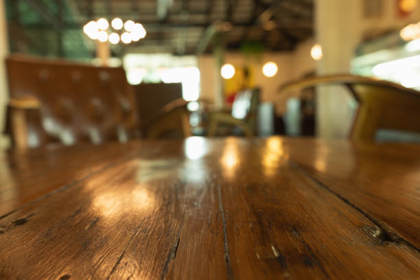 Empty wooden table top with lights bokeh on blur restaurant background.