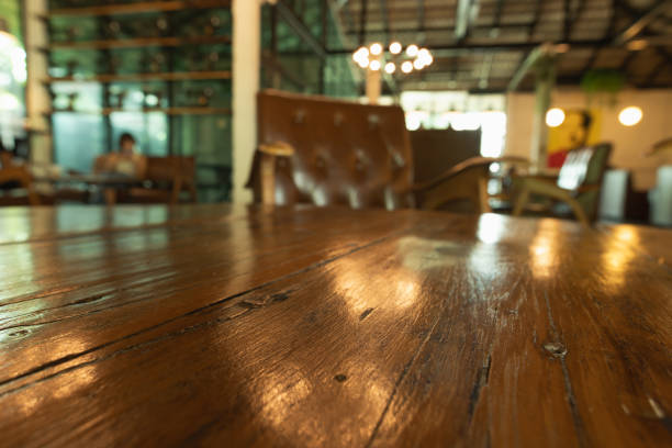Empty wooden table top with lights bokeh on blur restaurant background.