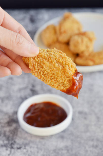 istock Delicious crispy chicken wing dipping in BBQ sauce 2161021302