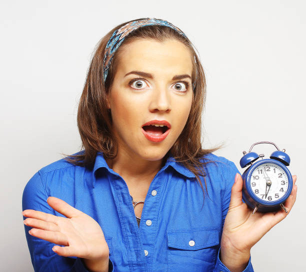 istock Young woman with alarmclock 2161023790