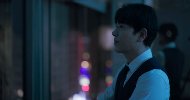 Portrait Of Young Asian Man Outdoors At Night With Arms Crossed