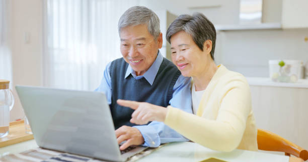 istock asian elderly couple use laptop 2161035777