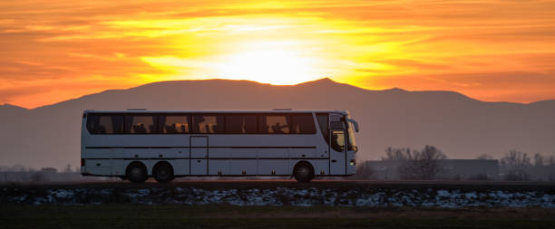 Intercity passenger bus driving on highway road in evening