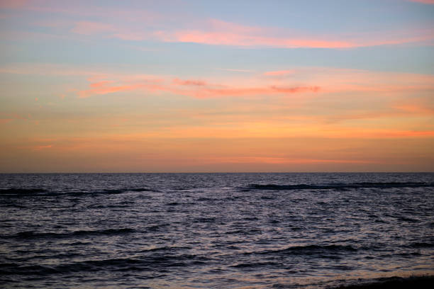 Dramatic red ocean waves at sunset with soft evening sea dark water.