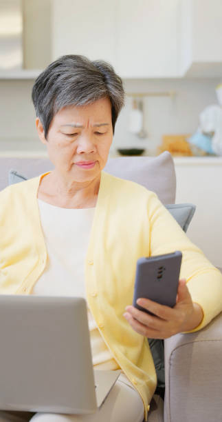 istock older female laptop mobile scammed 2161036862