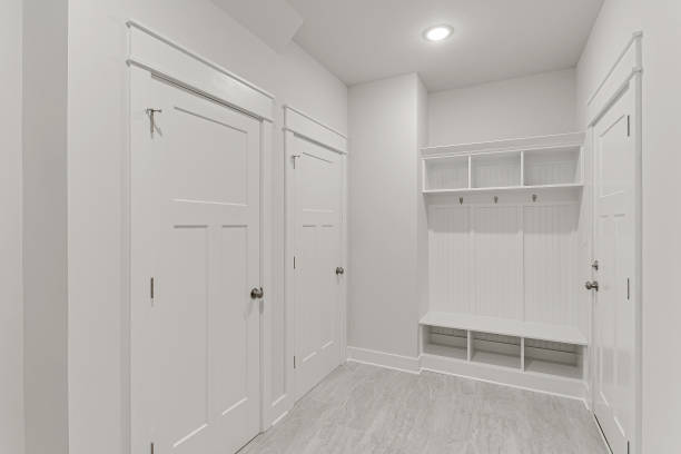 istock Bright And Roomy Mudroom With White Doors, Hooks, And Storage Bench. 2161041090