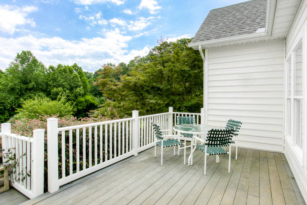 Open Deck With White Railing And Green Chairs Under A Bright Blue Sky.