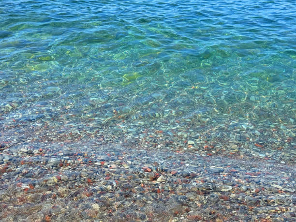 istock Blue sea waves on pebble beach 2161041959