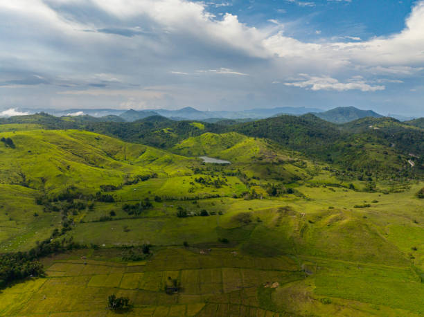 Tropical mountain with farmland over the blue sky and clouds. Mindanao, Philippines.