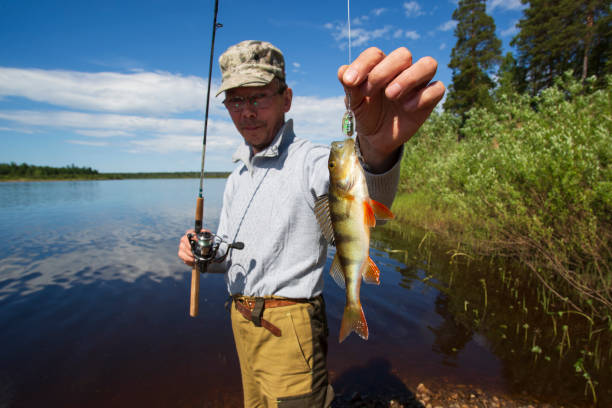 istock A man with a spinning is fishing on the river. 2161049373