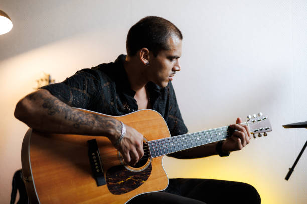 istock Young guitarist playing acoustic guitar in musical studio 2161051744