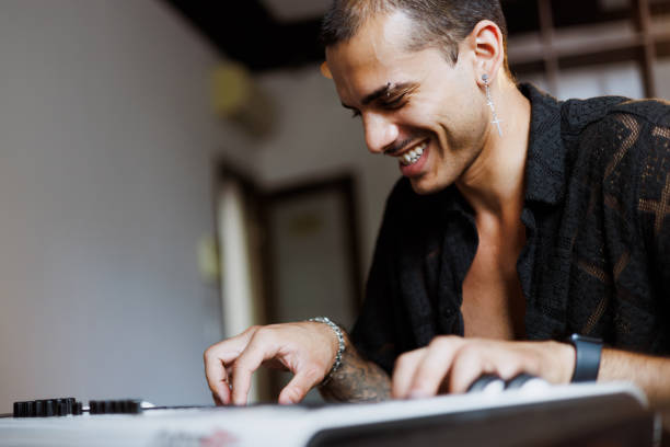 Closeup photo of male hands playing on electronic keyboard. Close-up of hand playing piano keys during casual home music practice.