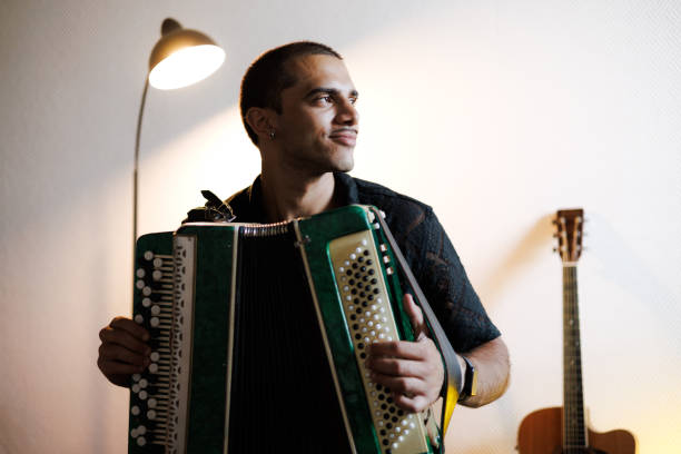 istock Young joyful musician playing accordion in music studio 2161052729