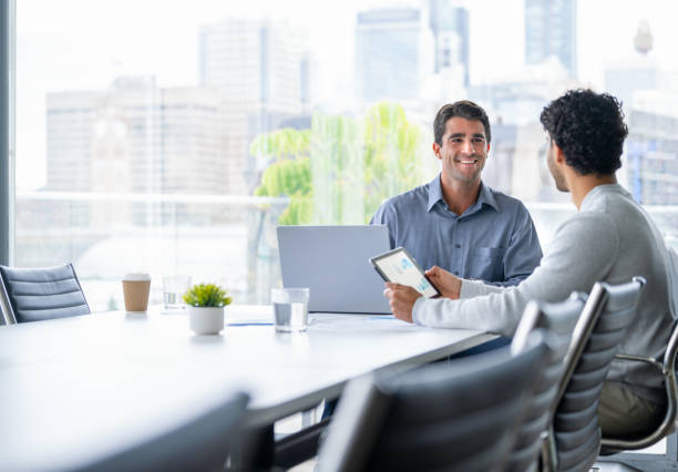 istock Two businessmen working on a digital tablet and laptop computer in the office. 2161058062