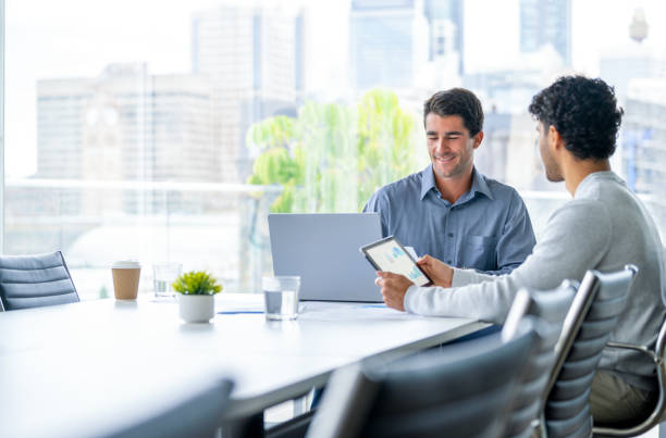 istock Two businessmen working on a digital tablet and laptop computer in the office. 2161058124