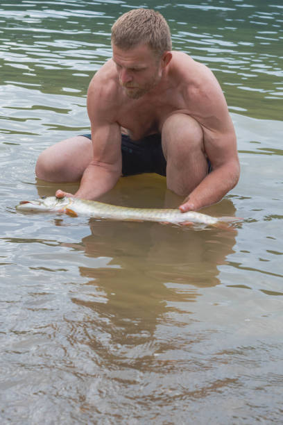 Man holding a Muskie pike fish caught from a  shore allegheny state forest kinzua beach