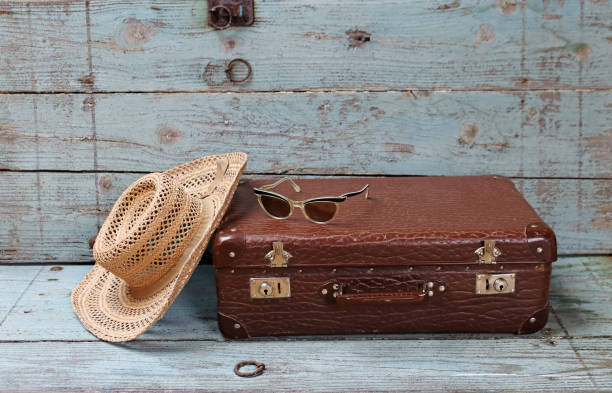 istock Off on vacation. An old suitcase with a straw hat and sunglasses 2161063369