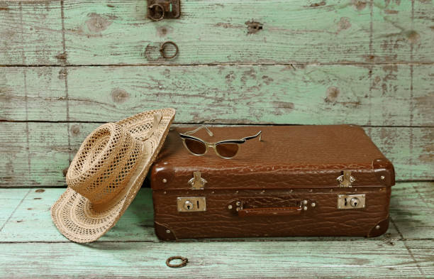 istock Off on vacation. An old suitcase with a straw hat and sunglasses 2161063376