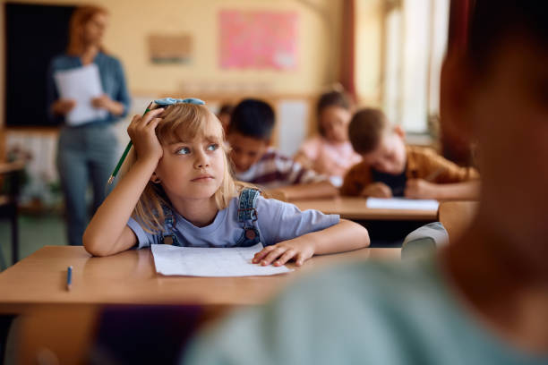 istock Little girl thinking while having a test at elementary school classroom. 2161063551