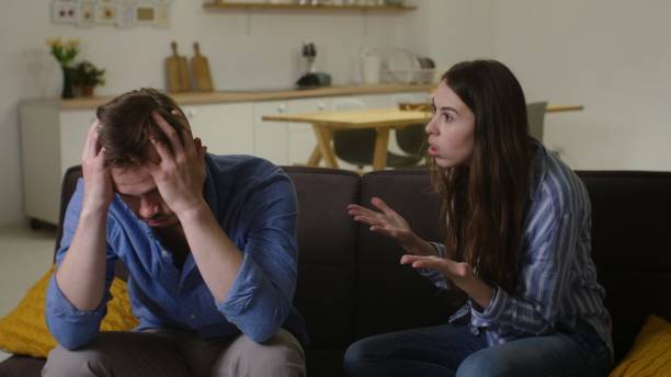 istock Comforting Embrace: Woman Offering Support to Upset Partner on Sofa 2161065111
