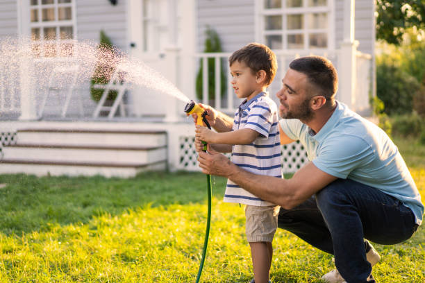 istock A father and son are watering the grass with hosepipe 2161069192