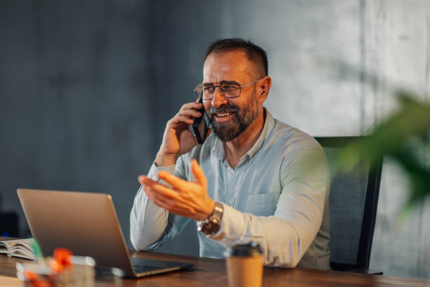 istock Friendly businessman at modern office having phone call with clients. 2161069687