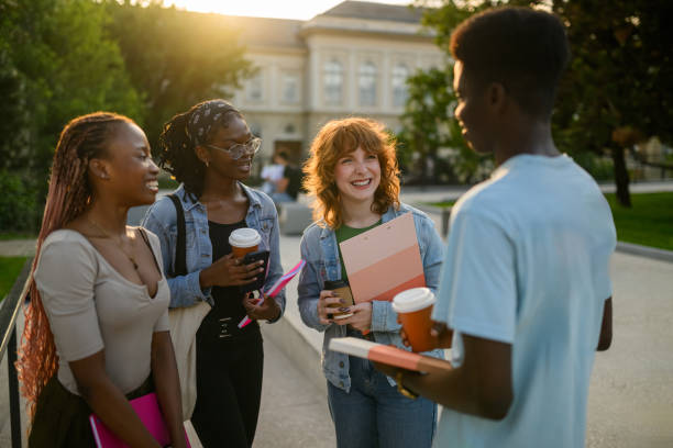 istock Interracial students at campus smiling at chatting on a coffee break. 2161069747