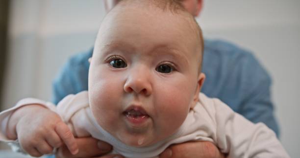 istock Adorable Baby with Big Eyes Held by Father 2161071530