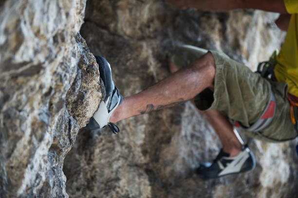 Close-up of rock climber climbing  up the cliff.