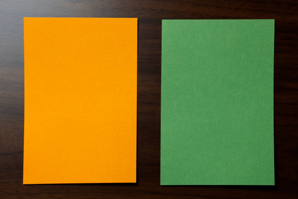 Blank orange and green paper note on wooden background, copy space