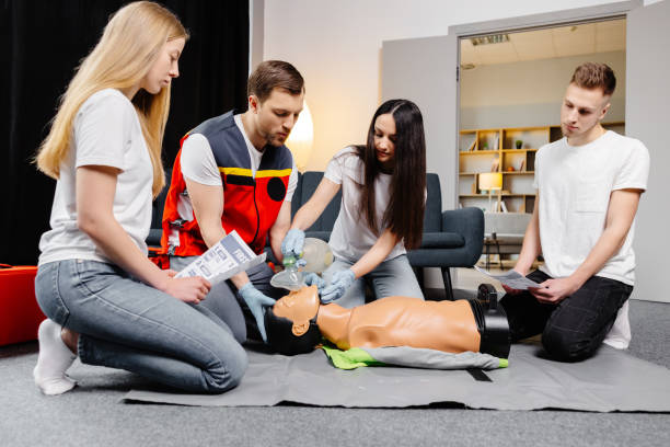istock Group of people learning how to make first aid heart compressions with dummies during the training indoors 2161093694