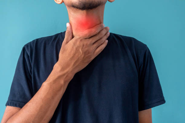 istock Man has sore throat and touches his throat 2161095131