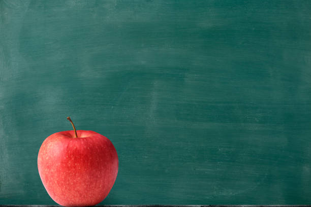 A red apple in front of the blackboard with copy space. \nBack to School concept.
