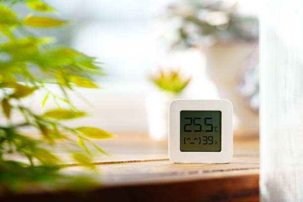 Digital Thermometer Displaying Temperature and Humidity Near Window