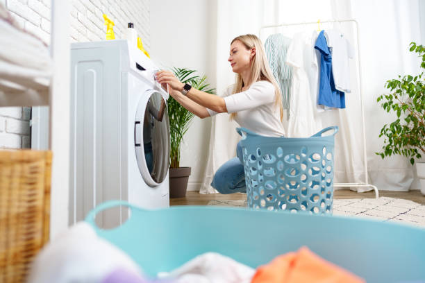 istock Woman Doing Laundry near a Washing Machine 2161102324