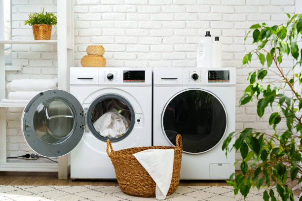 istock Open Washing Machine With Pink and Yellow Clothes in a Modern Laundry Room 2161102328