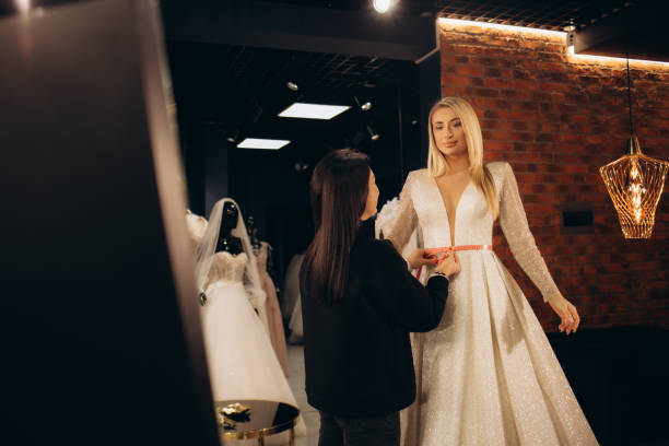 istock Attractive bride choosing a wedding dress in the store. 2161106980