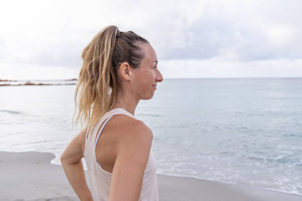 istock Woman Looking at Sea on Beach 2161108996