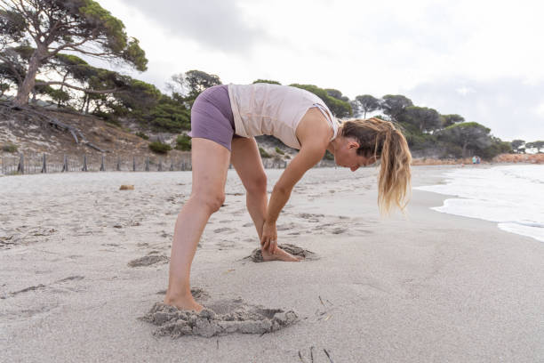 istock Woman Stretching on Beach Sand 2161113912