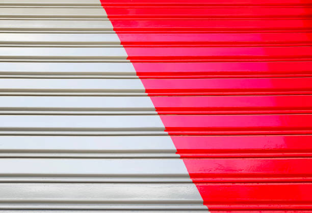 Closed up painted corrugated metal door backround. Red and grey color paint on rolling shutter door.