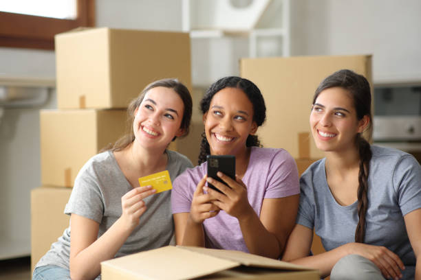 istock Three happy roommates dreaming buying online moving home 2161117473