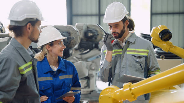 istock Group of multiracial colleague working and maintain automate robotic arms machine while training and research in warehouse manufacturing industry 2161119858