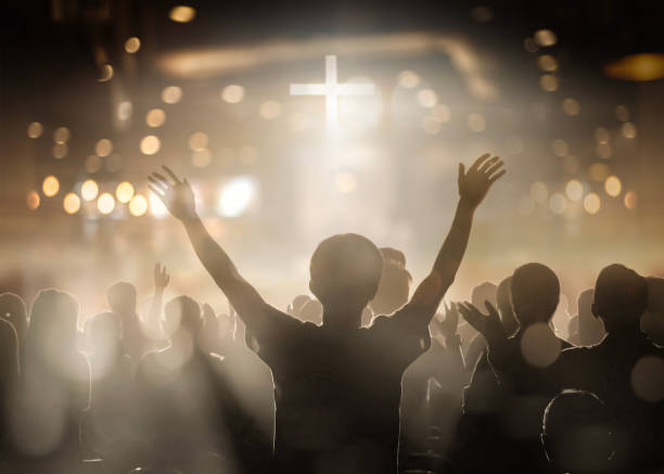 Christians raising their hands in praise and worship at a night music concert Christians raising their hands in praise and worship at a night music concert. Eucharist Therapy Bless God Helping Repent Catholic Easter Lent Mind Pray. Christian concept background. place of worship stock pictures, royalty-free photos & images