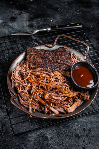 istock Slow Cooked Pulled Beef, Traditional meat rubbed with spices and smoked in a Texas smoker. Black background. Top view 2161126343