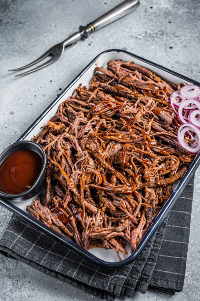 istock Pulled beef meat with hot chili sauce in baking dish. Gray background. Top view 2161126348