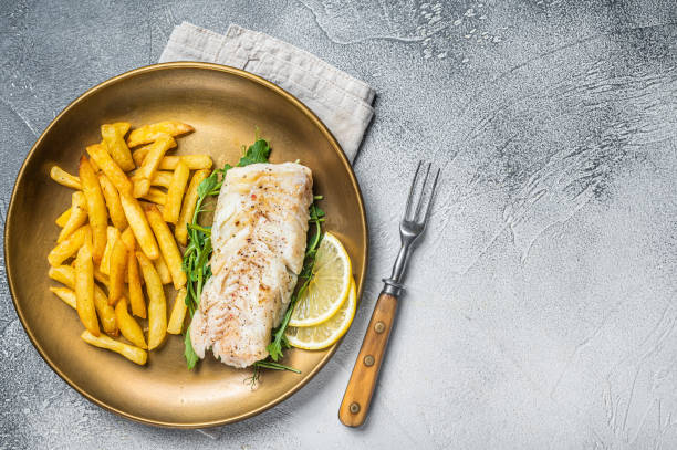 Fried cod fish fillet served with french fries. White background. Top view. Copy space