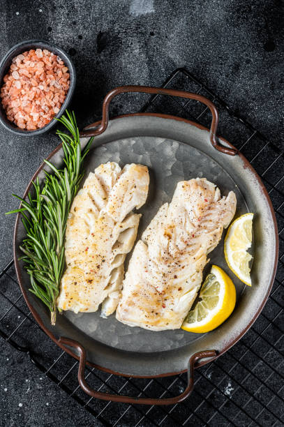 istock Roast Fillets of codfish, cooked cod fish meat. Black background. Top view 2161126460