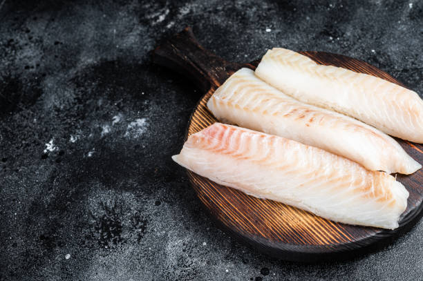 istock Fillets of codfish, raw cod fish meat. Black background. Top view. Copy space 2161126615