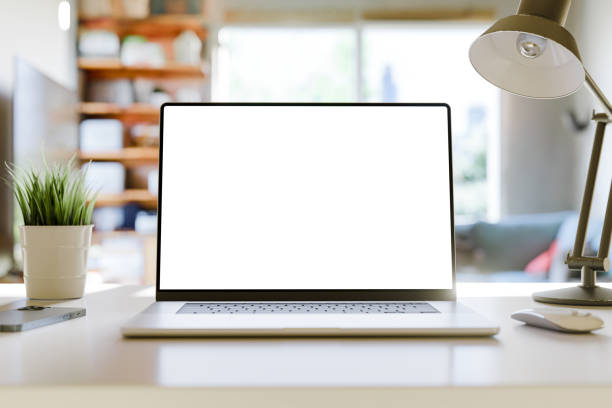 istock Laptop with a blank screen on a table in a bright home office. Perfect for inserting your own content. 2161127609