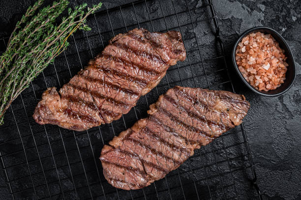 istock Grilled denver beef meat steak on a rack. Black background. Top view 2161128648